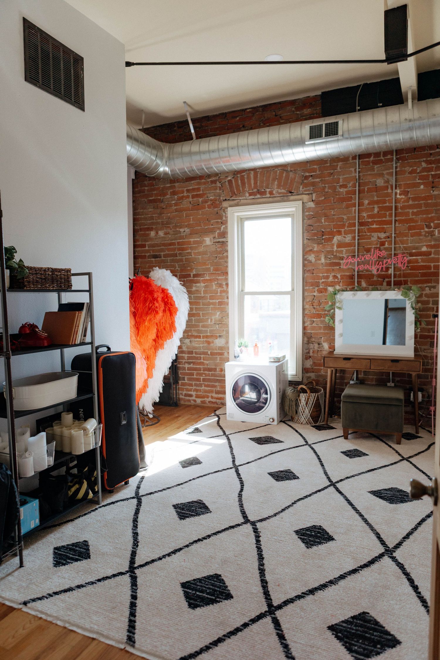 A series of photos showing a modern loft space with exposed brick walls and geometric black and white floor patterns.