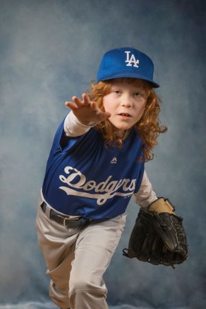 A boy throwing a baseball at the camera.