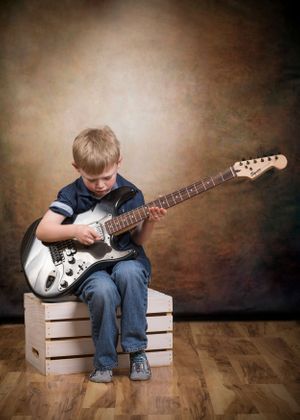 Little boy playing the guitar.