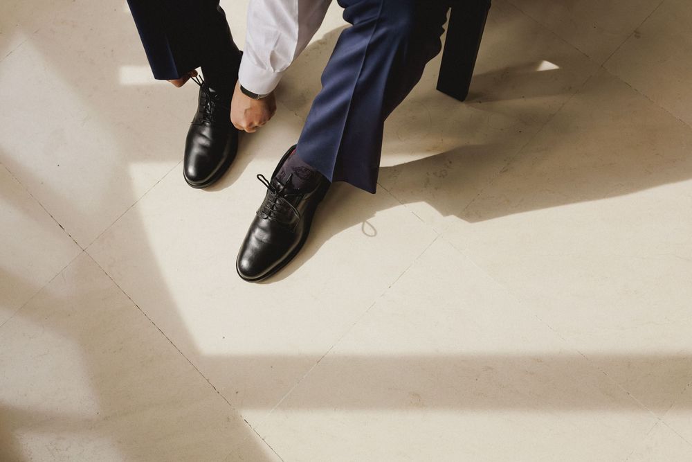 Close-up of the groom tying his shoes before the wedding ceremony.