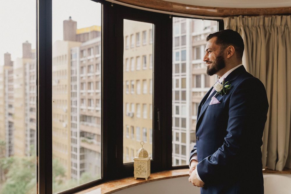 Portrait of the groom by the window during wedding preparations in Lisbon.