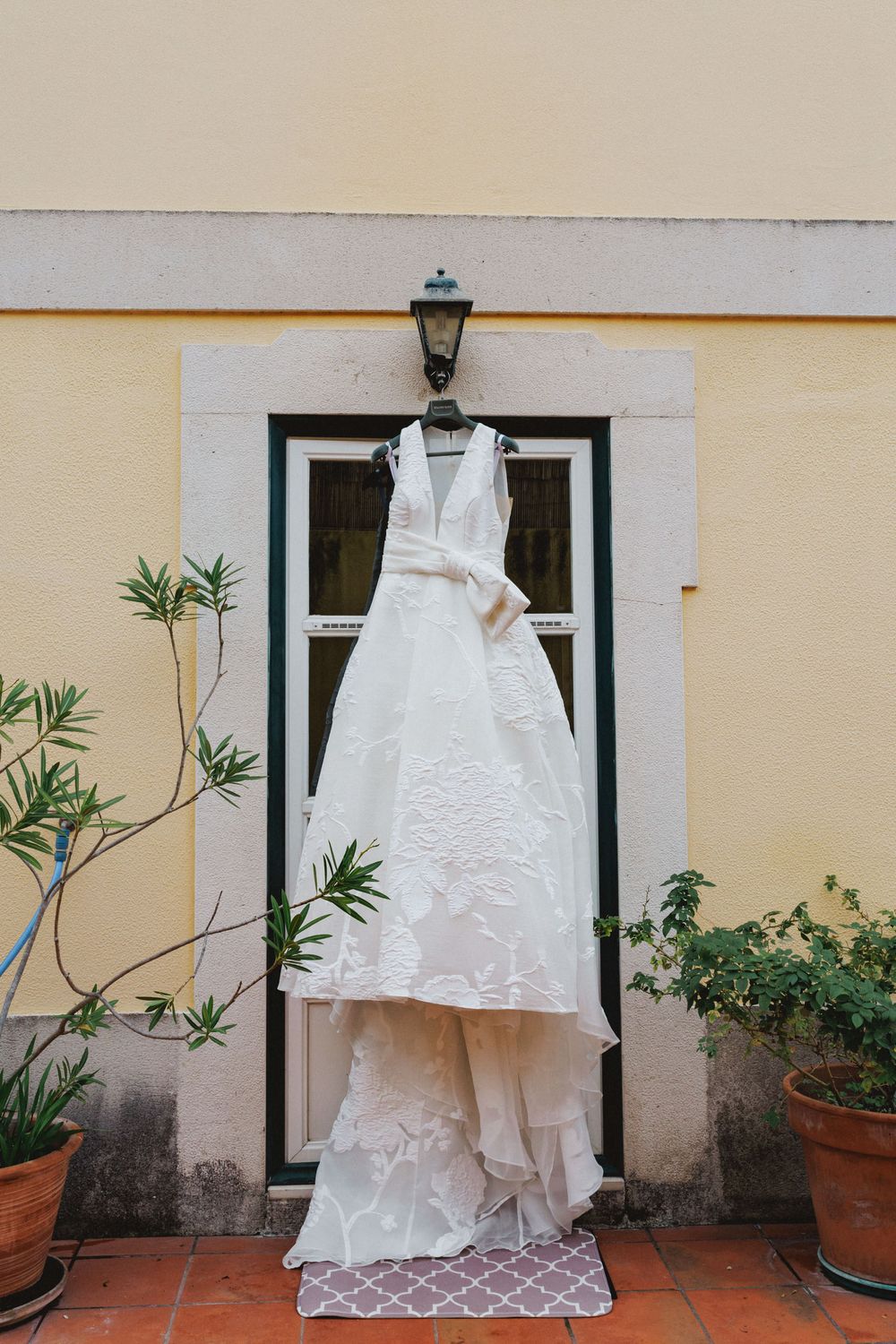 Bride's wedding dress hanging outside the house during wedding morning preparations
