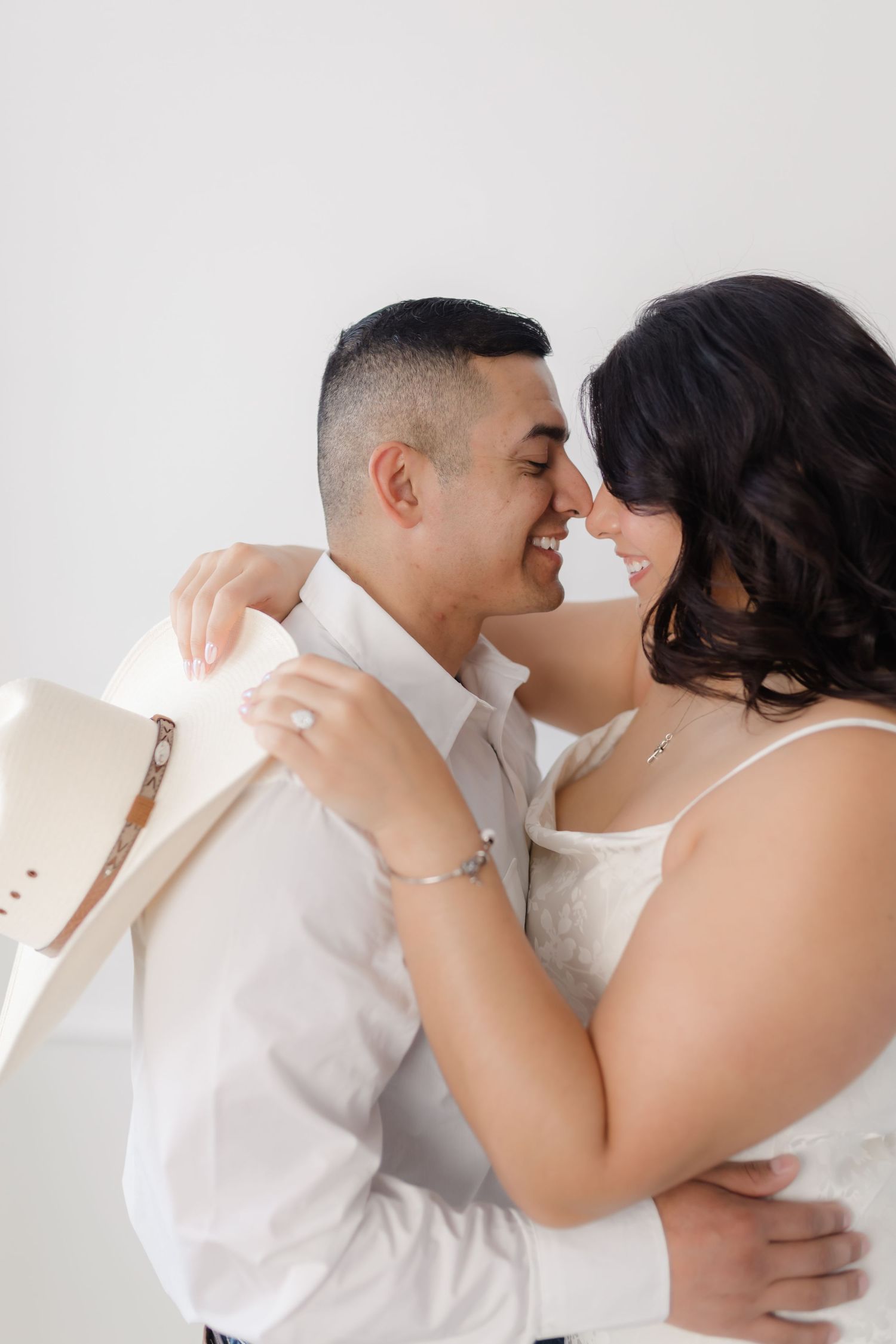 A romantic couple in white embraces tenderly in a series of intimate portrait photos.