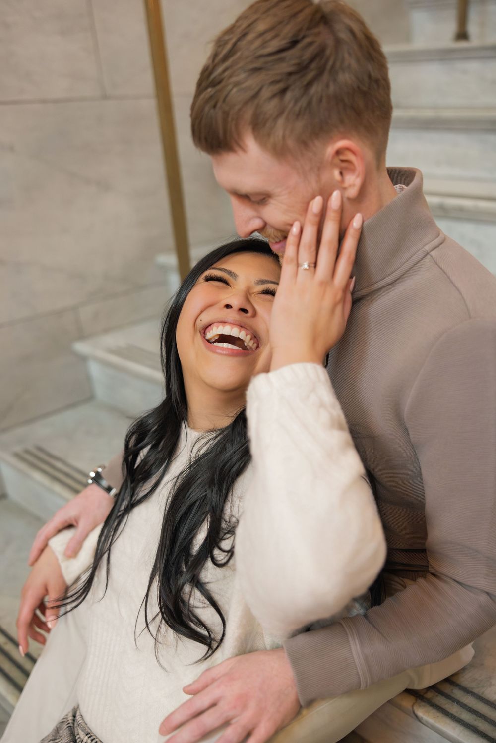 A couple laughs and embraces while lying on a striped rug in a series of candid romantic moments.