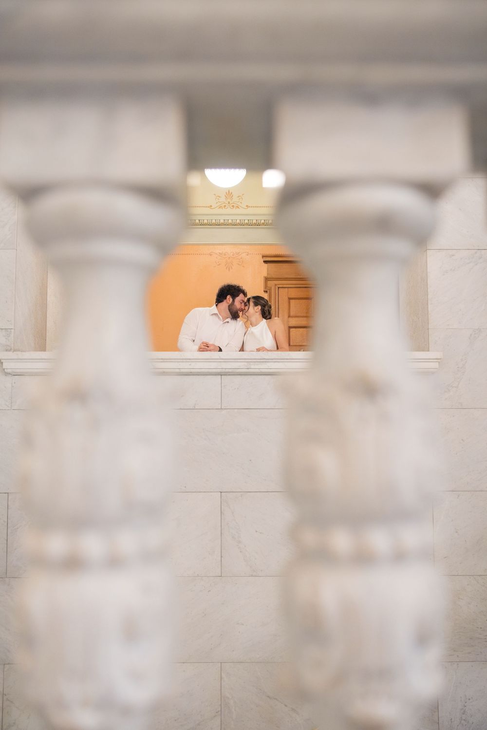 A romantic moment captured through architectural framing with soft lighting.