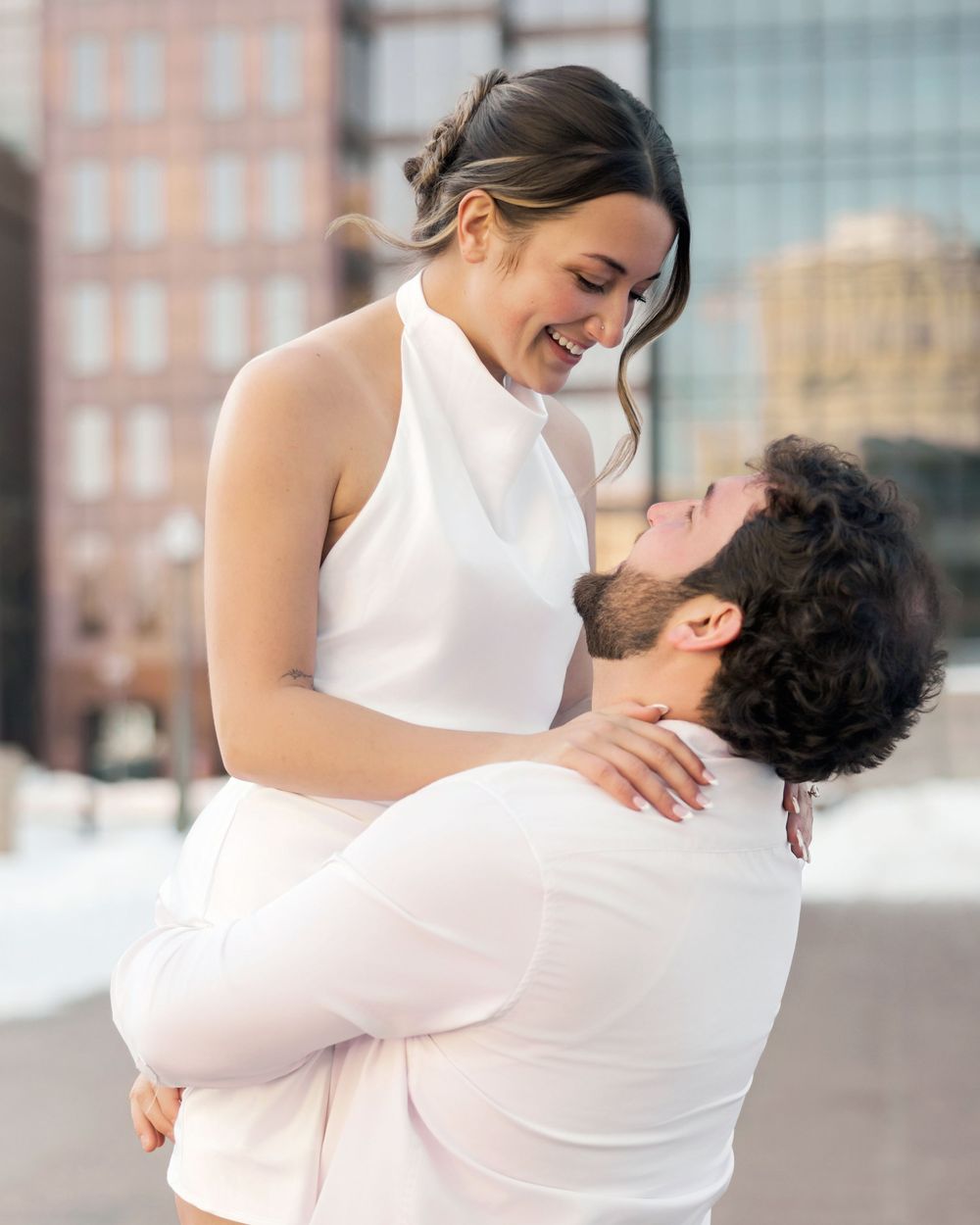 Dancing couple sharing playful moments in a series of romantic poses against a city backdrop.