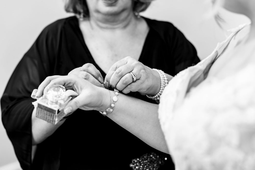 Close-up black and white photo of hands working with yarn and knitting needles while crafting a project.