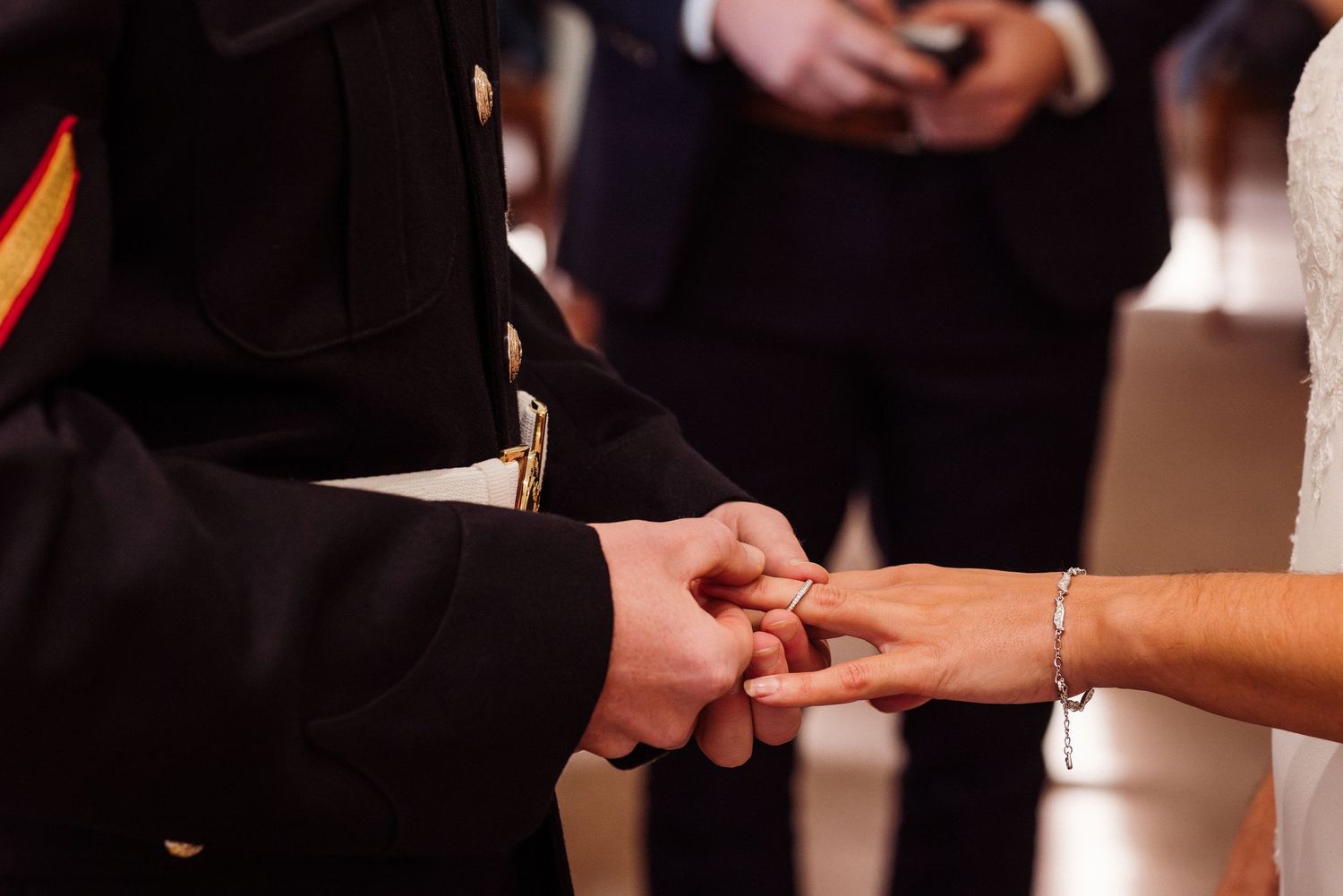 A couple exchanging rings during an intimate wedding ceremony indoors.