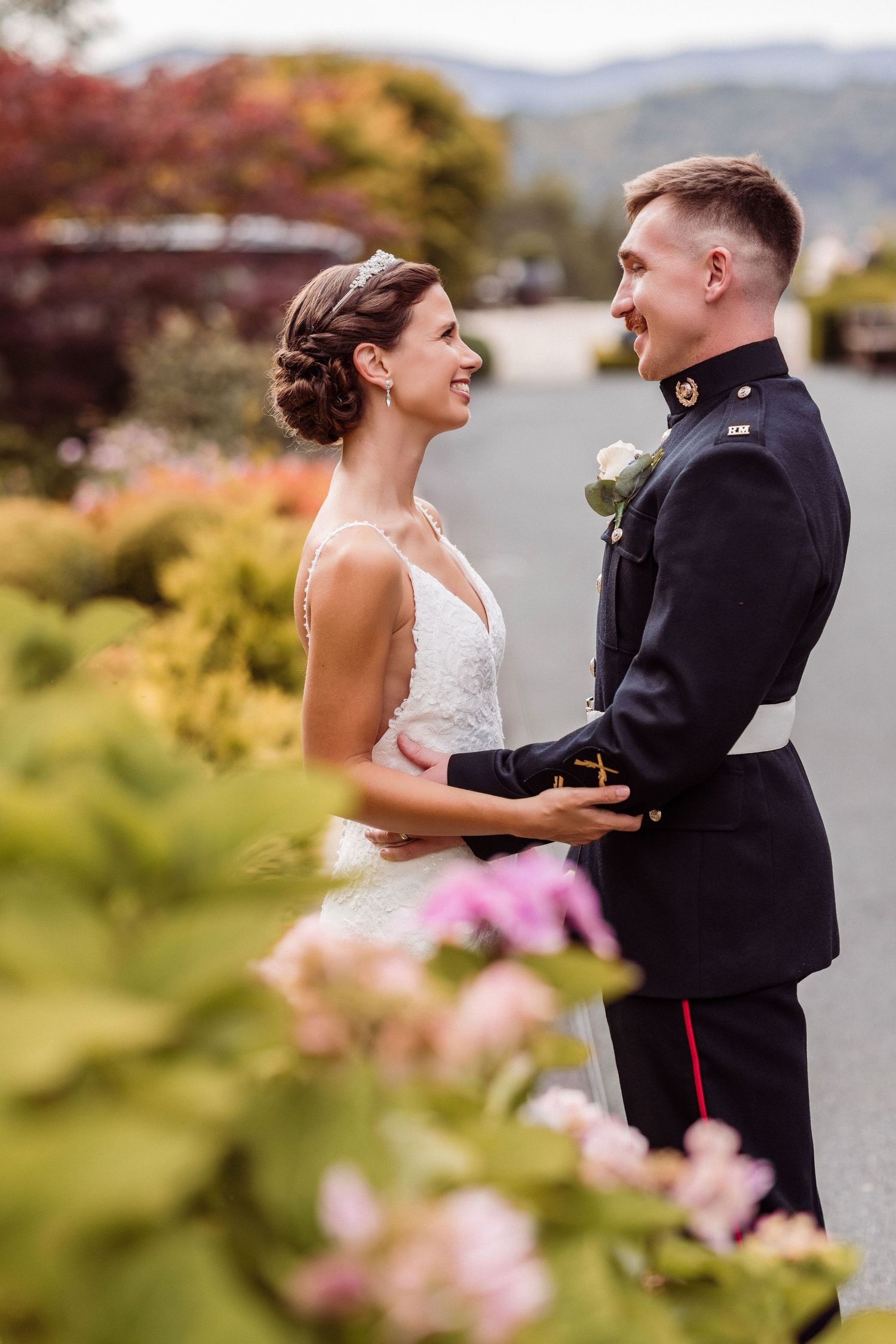 Couple shares joyful moments together in a garden setting with pink flowers and natural scenery.