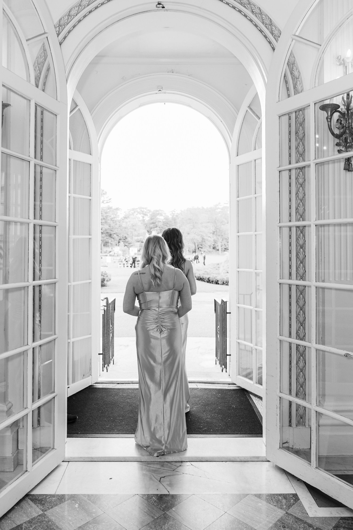 Black and white portraits at Tupper Manor in Beverly, MA featuring arched windows and elegant hallway architecture.