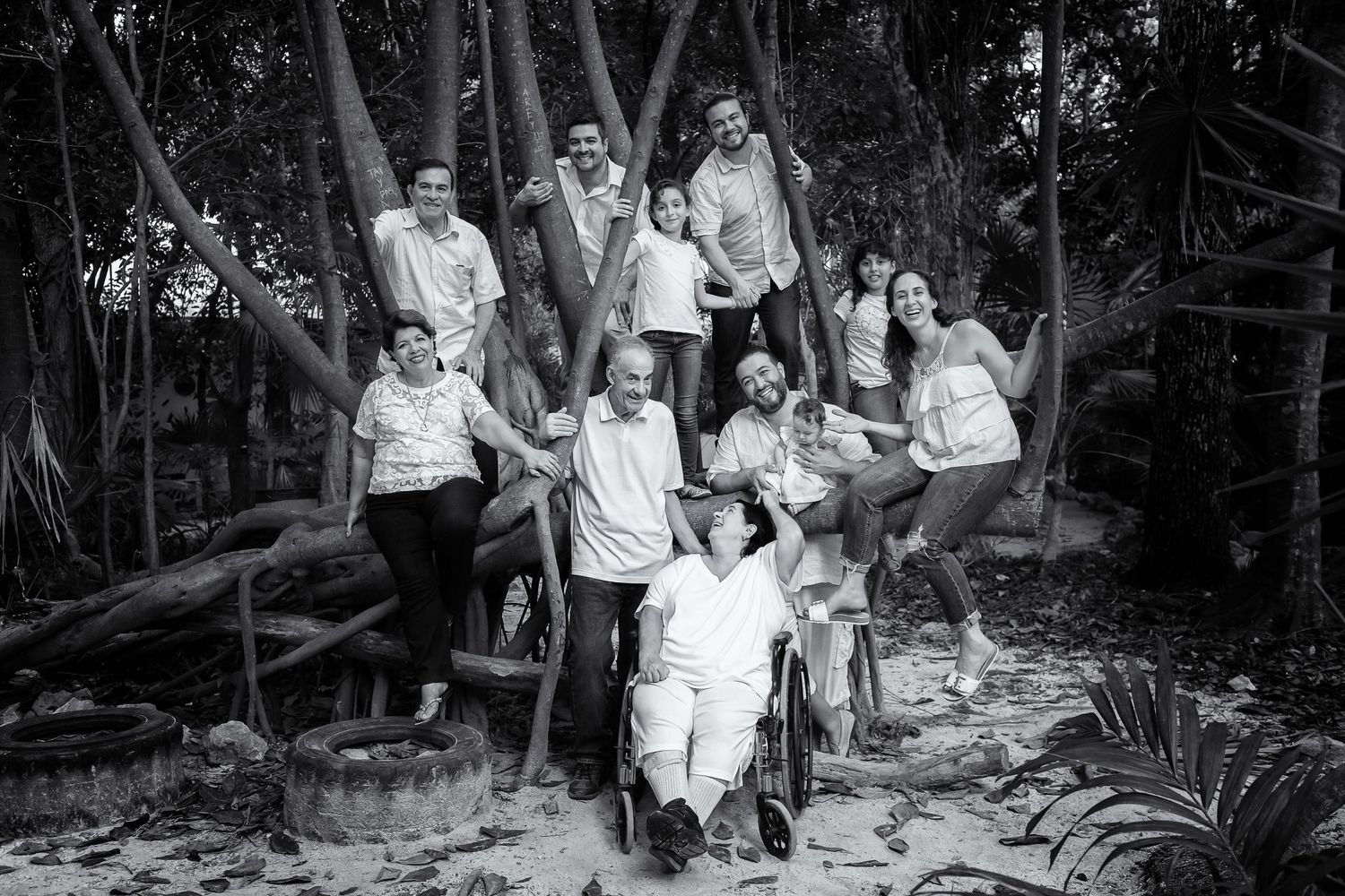 Black and white group photo of extended family gathered on tropical forest steps.