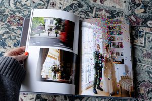 An open photo book or magazine displaying interior lifestyle photographs laid on a patterned rug or carpet.