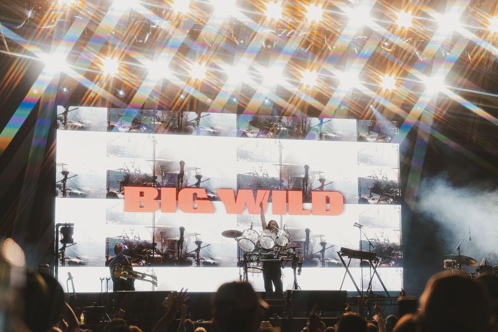 Concert stage with dramatic lens flare effects and lighting creating a dynamic visual atmosphere during performance.