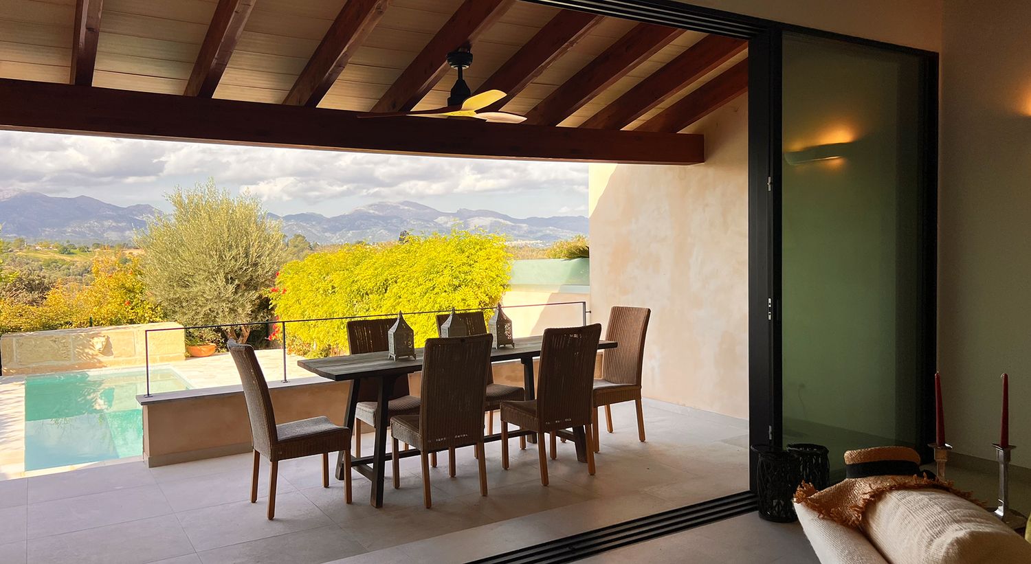 Luxurious outdoor dining area overlooking mountain views and swimming pool with comfortable seating.