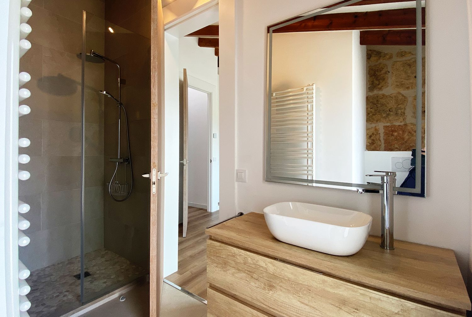 Contemporary bathroom with glass shower, vessel sink, and wooden countertop.