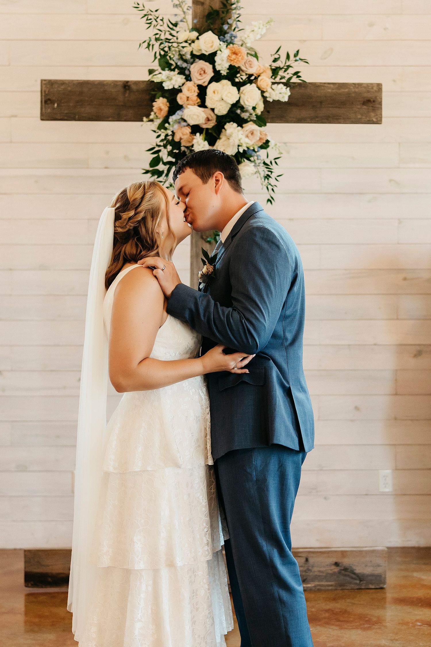 Wedding couple sharing intimate moments in a rustic white barn setting.
