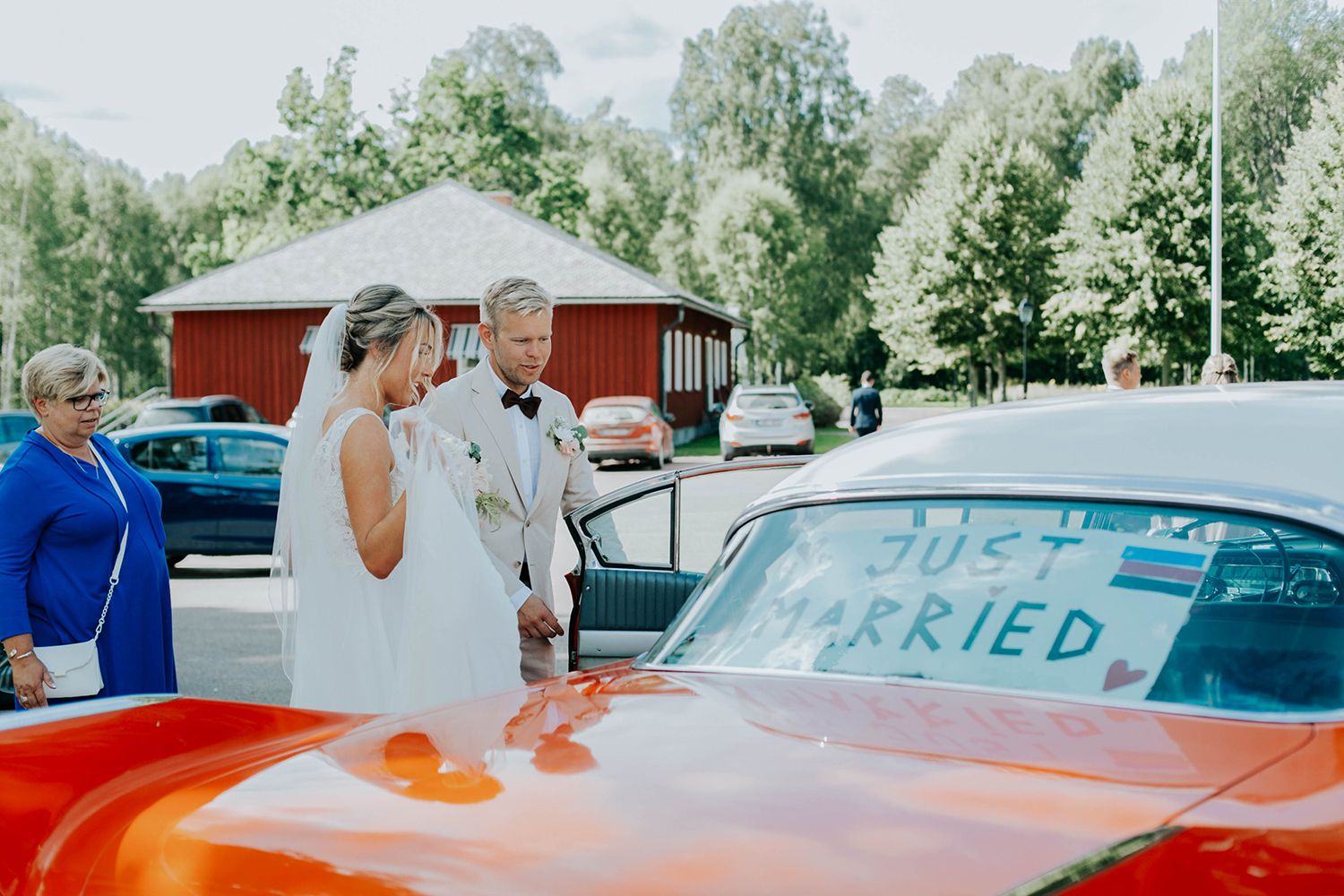 Malin och Olas bröllop i Nedre Ulleruds kyrka. Bröllopsfotograf i Karlstad Rebecca Nordin. Brudparet vid röd vintage bil