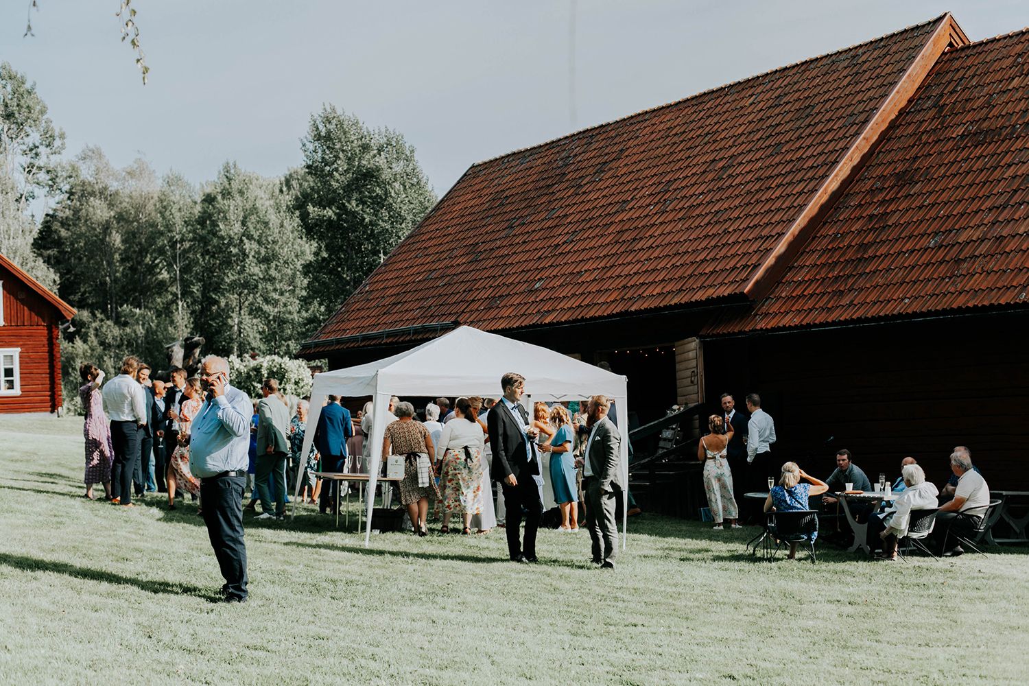 Malin och Olas bröllop vid Forshaga hembygdsgård.   Bröllopsfotograf i Karlstad Rebecca Nordin. Lada med bröllopsgäster.