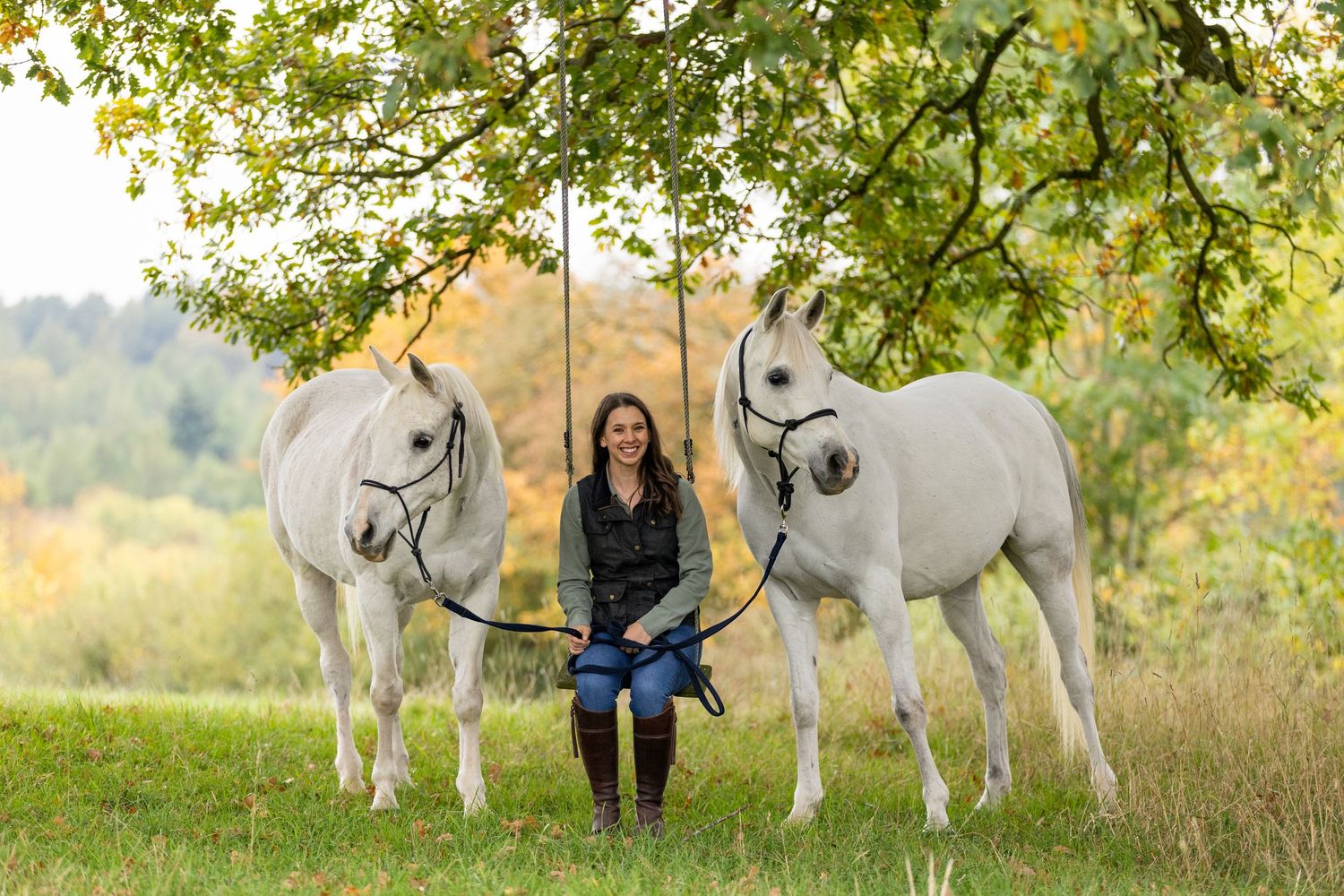 A horse and its rider enjoy an outdoor photoshoot session near rustic wooden fencing on a sunny day.