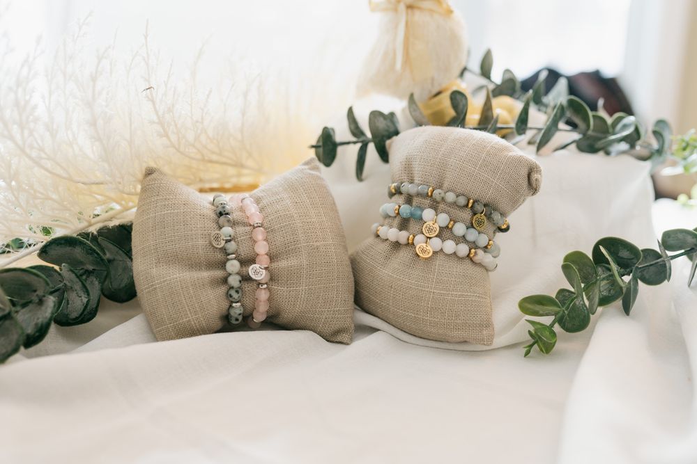 Rustic wedding decor with burlap wrapped mason jars, floral accents and green ivy garland on white surface.