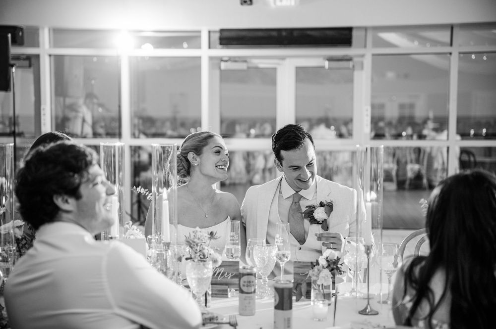 Wedding reception venue with elegant table settings and white draping across the ceiling.