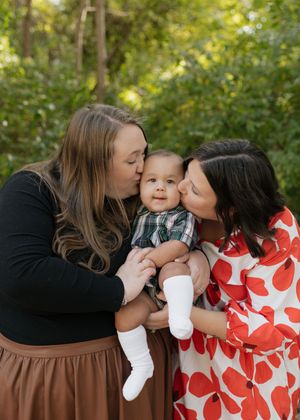A sweet family moment captured in a sequence of loving kisses and embraces outdoors.