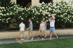 Walking sequence past blooming white roses along a garden path.