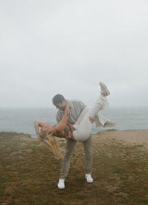 Playful poses captured in foggy weather on a coastal clifftop.