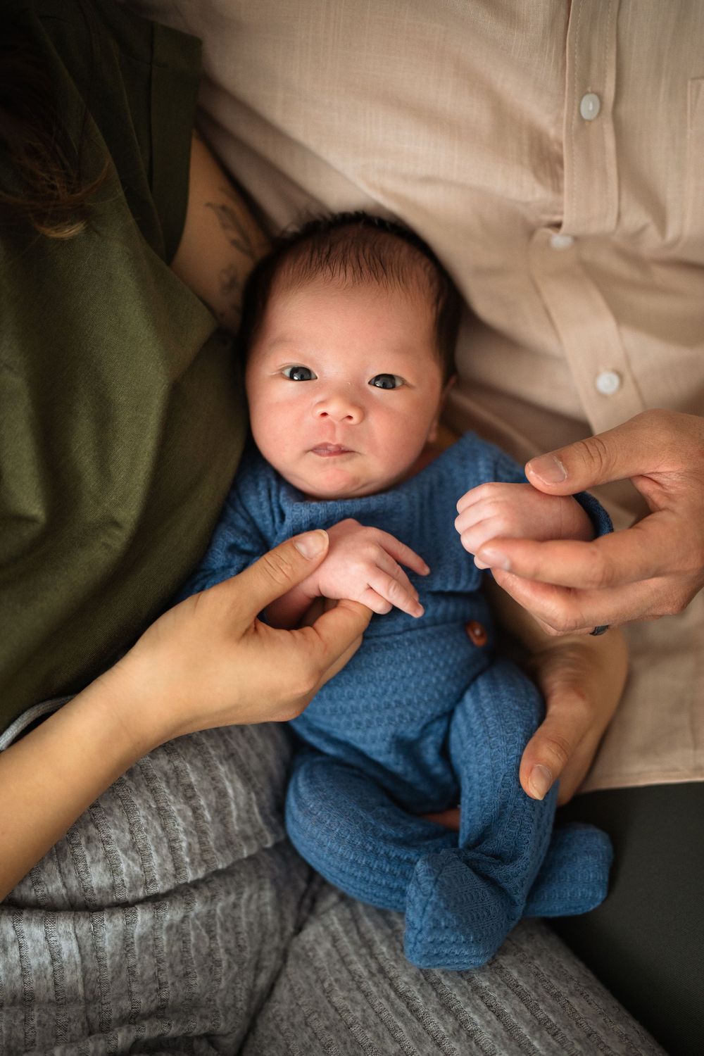 Close-up details of baby wearing blue outfit during family photo session.