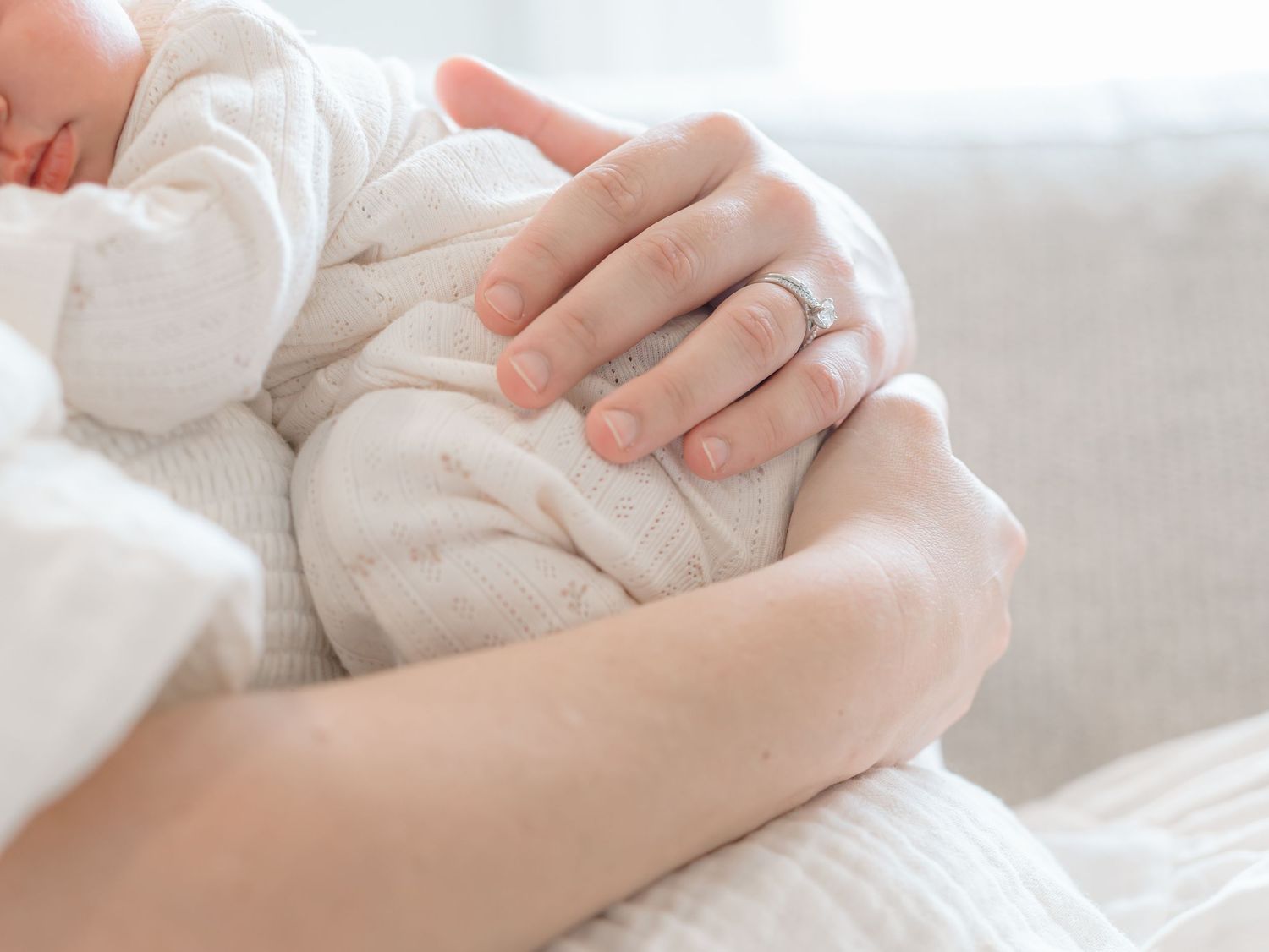 Close up image of mother's arms around her newborn baby.