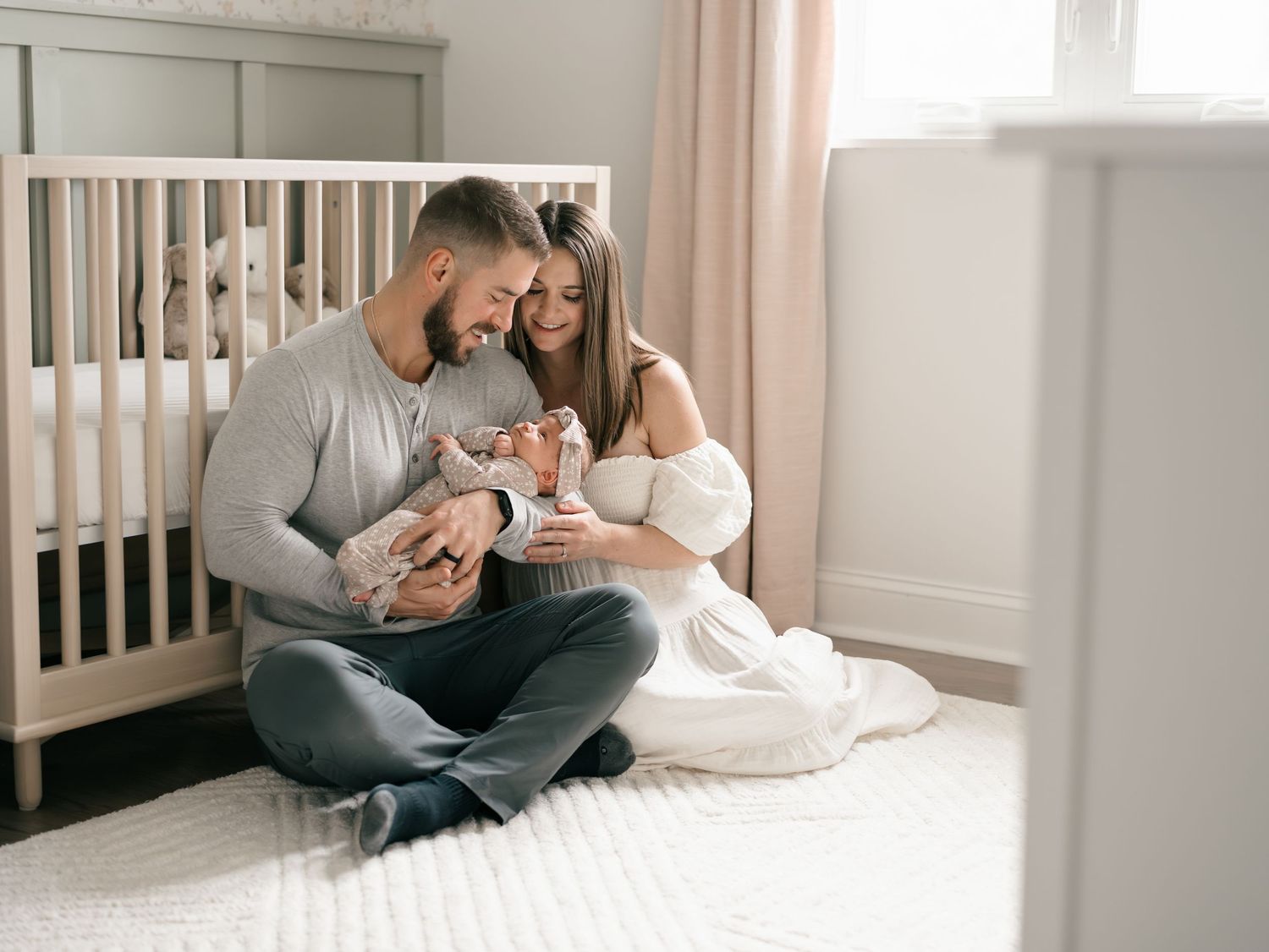 Family cuddling with their newborn during an in-home newborn photography session in Monmouth County NJ.
