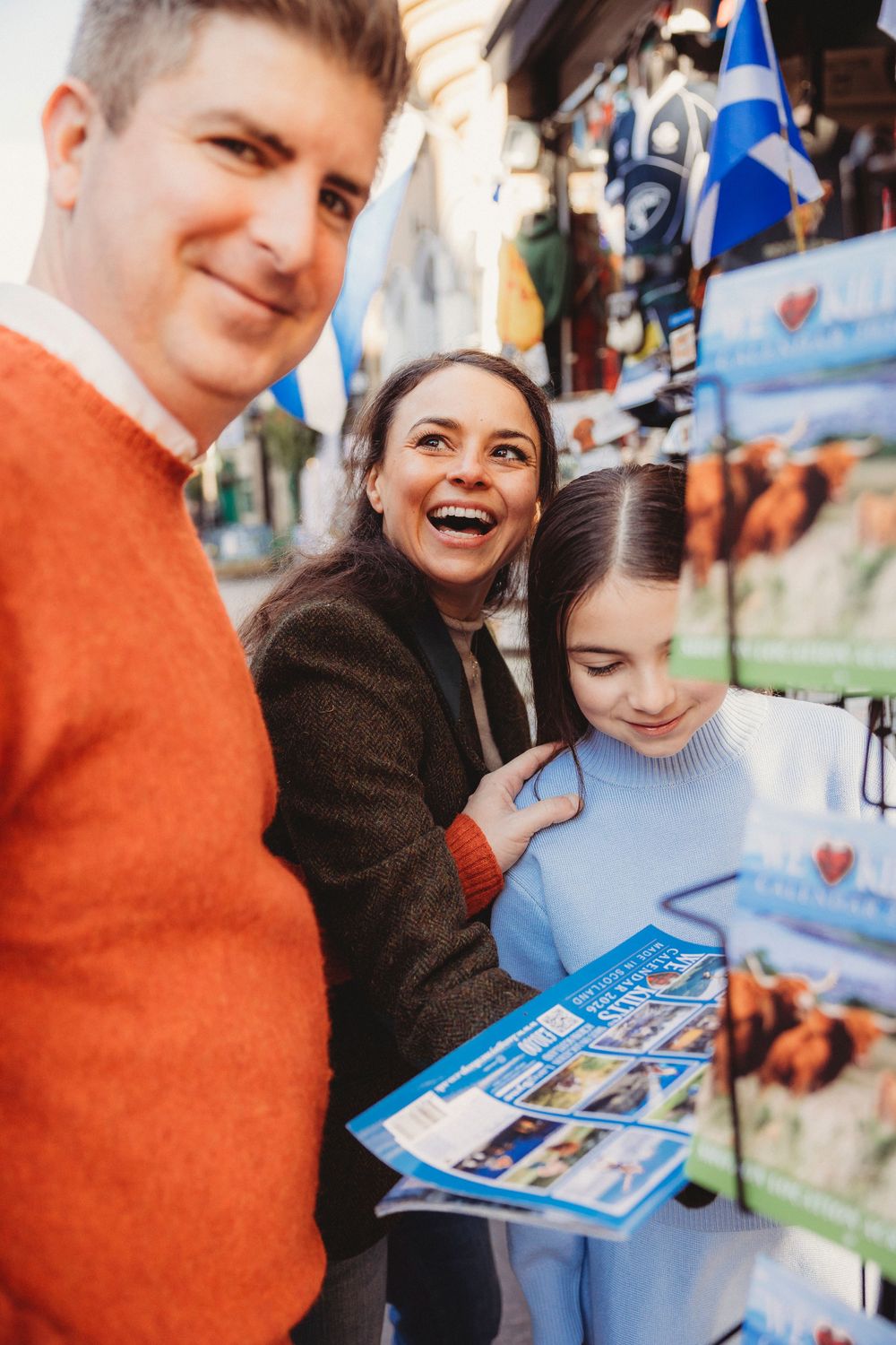 A group looking at a blue brochure together while sharing a joyful moment indoors.