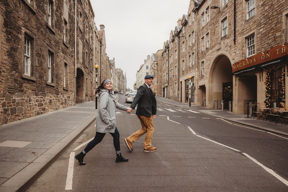 Row of traditional stone buildings along a cobblestone street in Edinburgh's historic Old Town district.