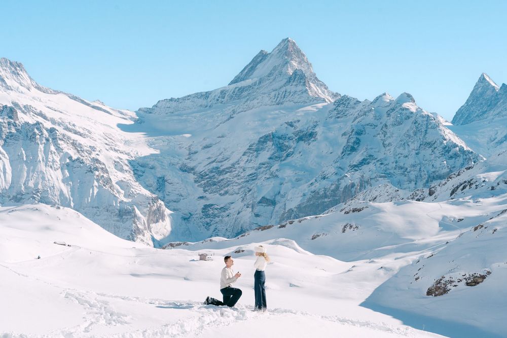 Panoramic view of snow-covered mountain peaks and ski slopes in the Swiss Alps during winter season.