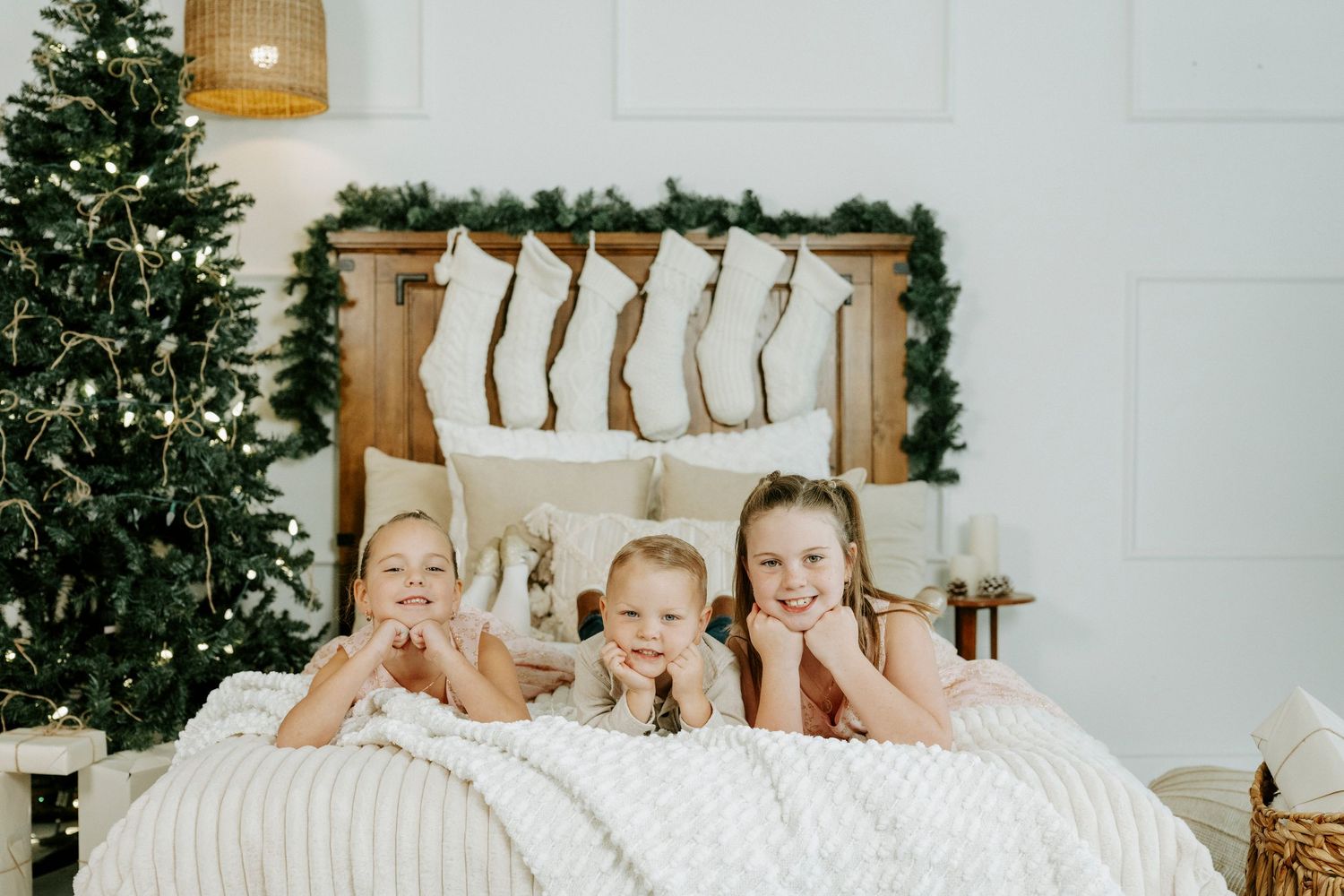 Five friends in matching pajamas having a fun slumber party near a Christmas tree.