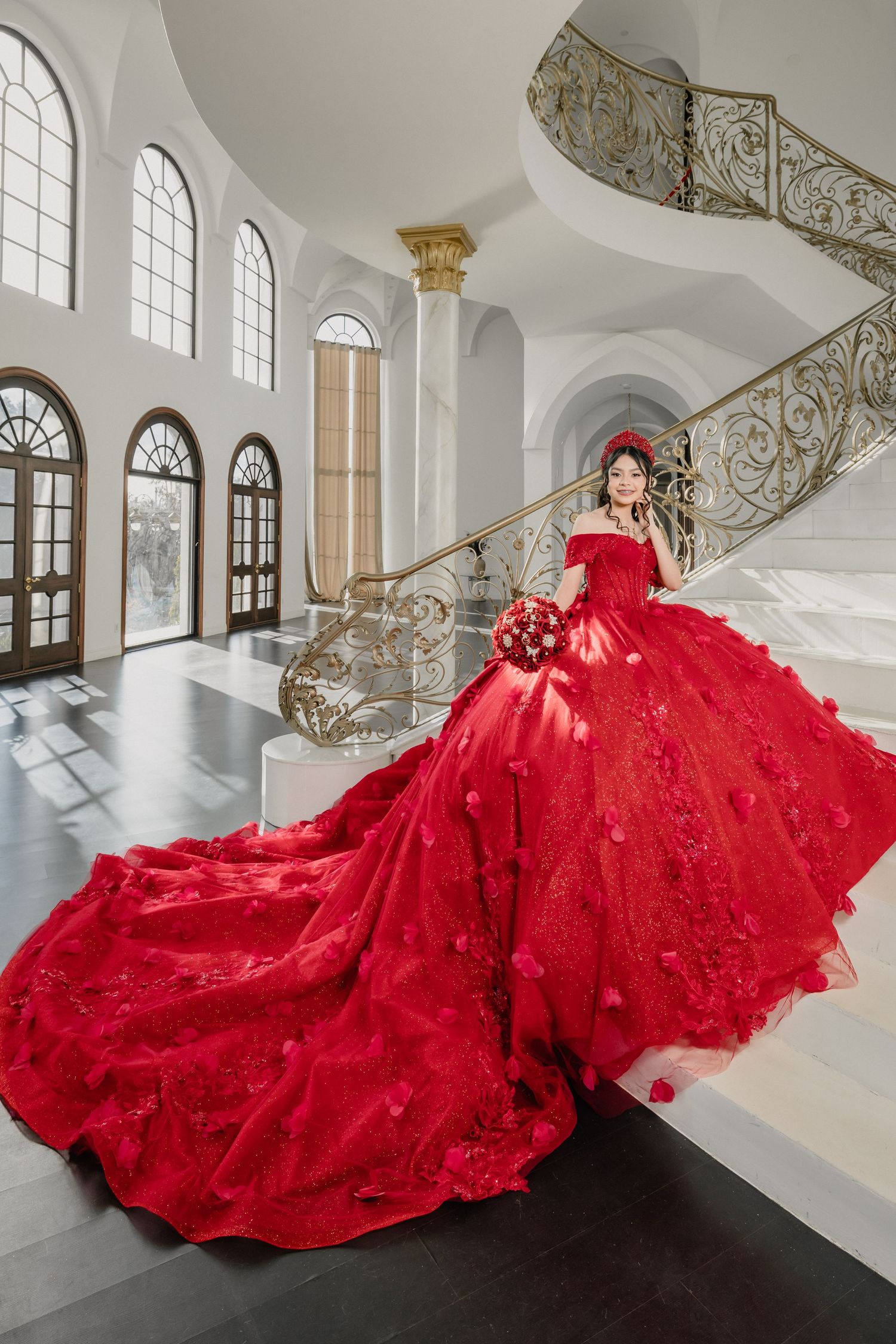 A luxurious red ball gown with intricate details spreads across a grand white marble floor.
