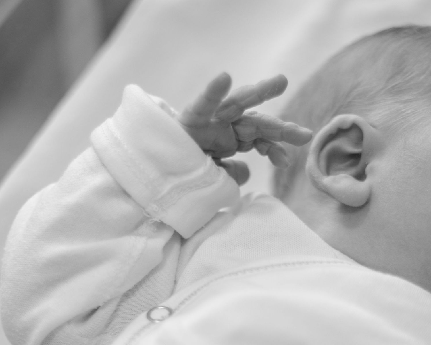 Close-up black and white photos showing hands holding an ultrasound photo.