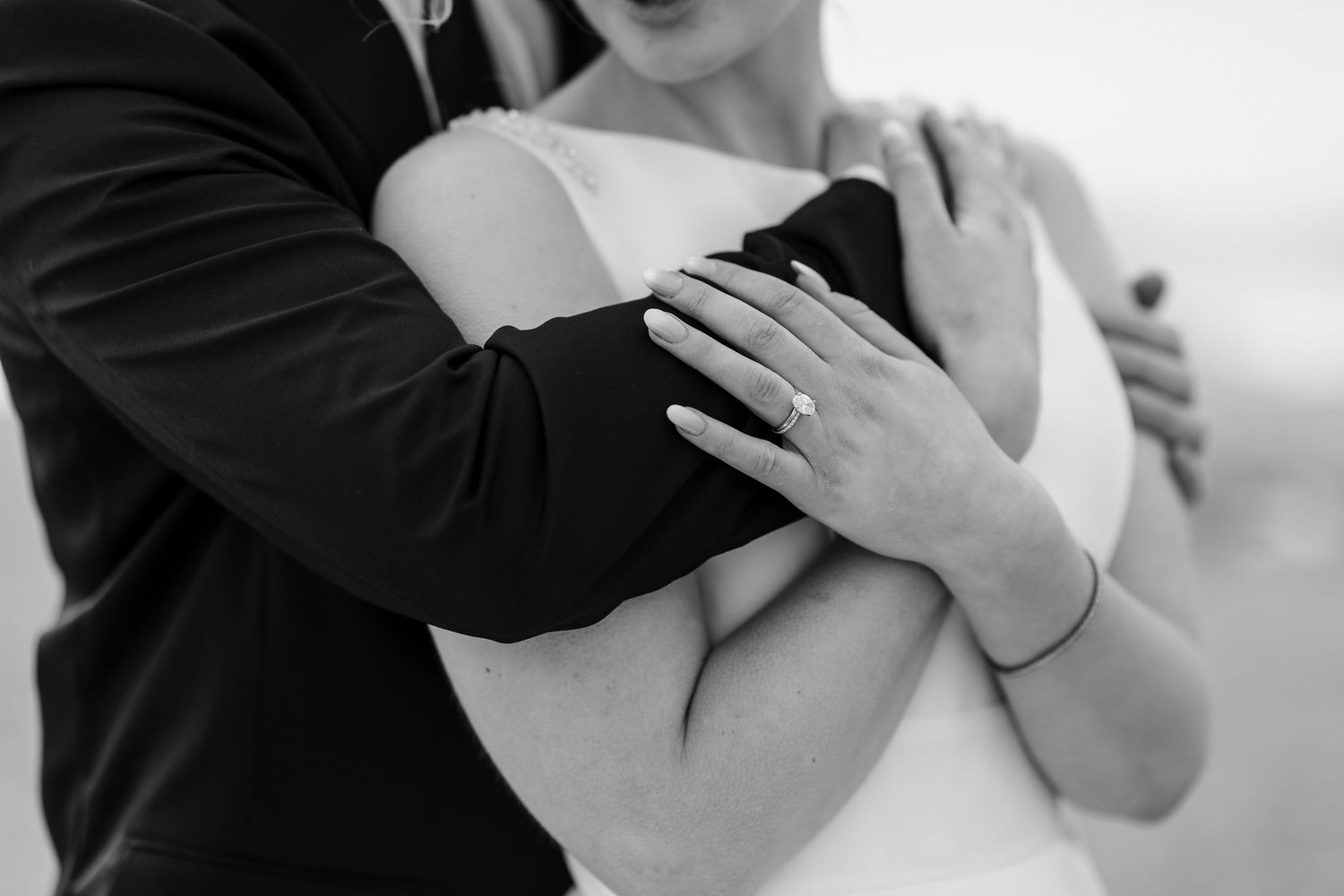 Black and white wedding photography shows a couple's intimate dance moment during their first dance at the reception.
