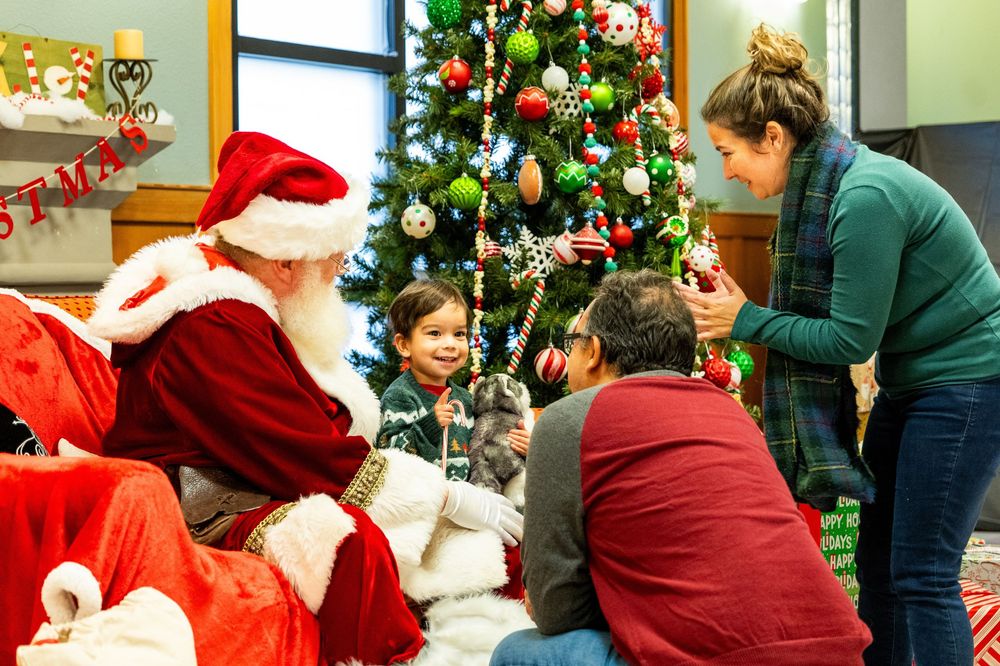 Holiday celebration with decorated Christmas trees and festive decorations in an indoor setting.