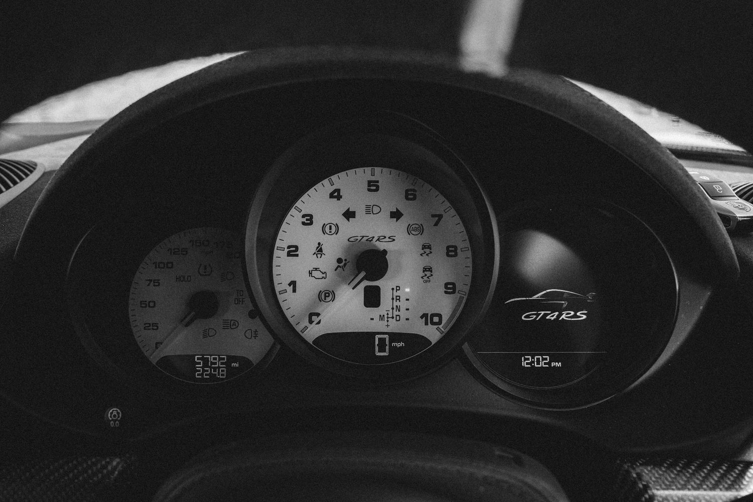 Black and white dashboard gauges showing speed and RPM indicators in a performance vehicle.