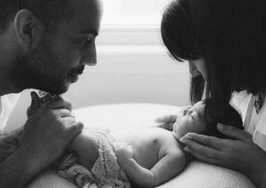 A series of black and white photos showing tender moments between parent and newborn baby in a hospital setting.