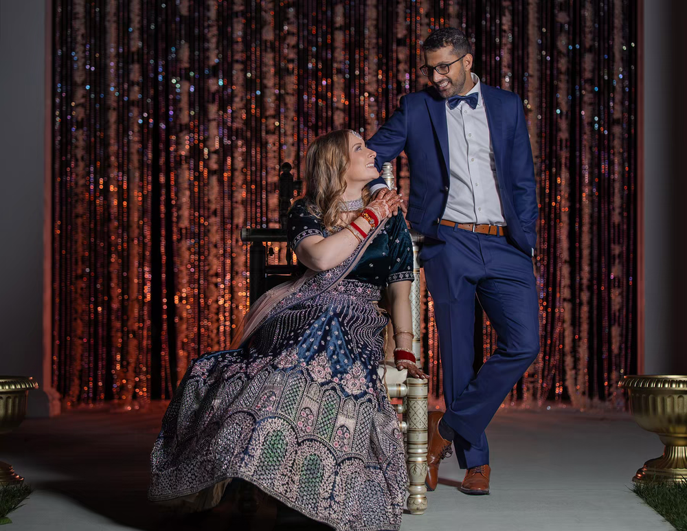 A newlywed couple poses on a stage with sparkling red curtains in the background in Columbus Ohio Wedding Venues