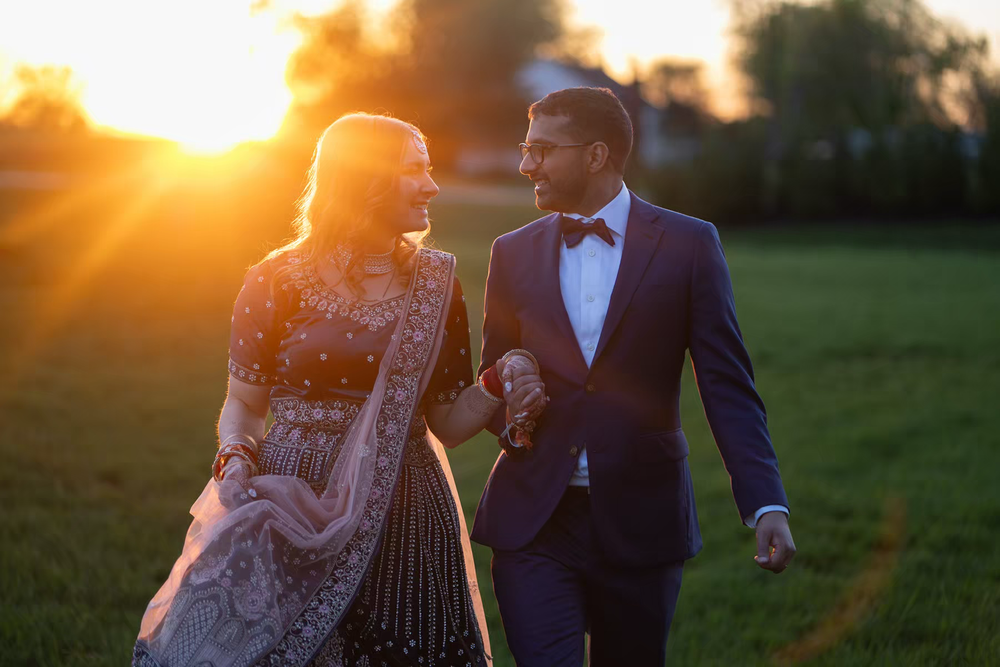 A newlywed couple shares an intimate moment during golden hour in a grassy field at sunset in Columbus Ohio
