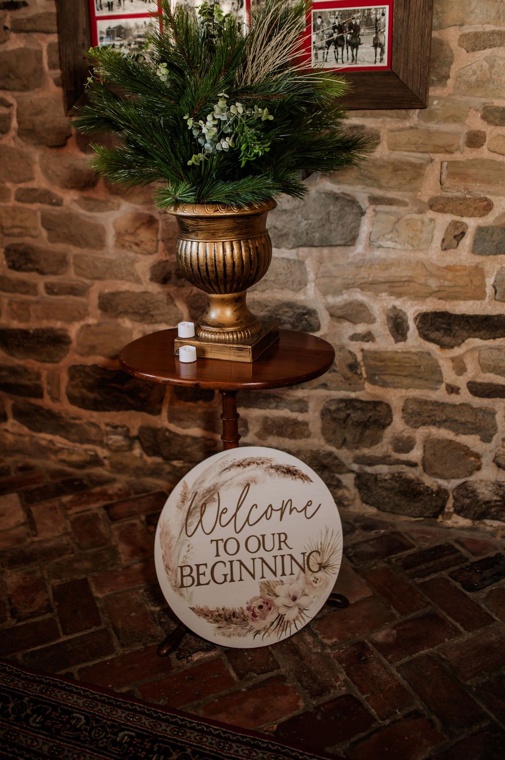 Rustic stone wall decor featuring a 'Welcome to our beginning' sign and elegant potted plants.