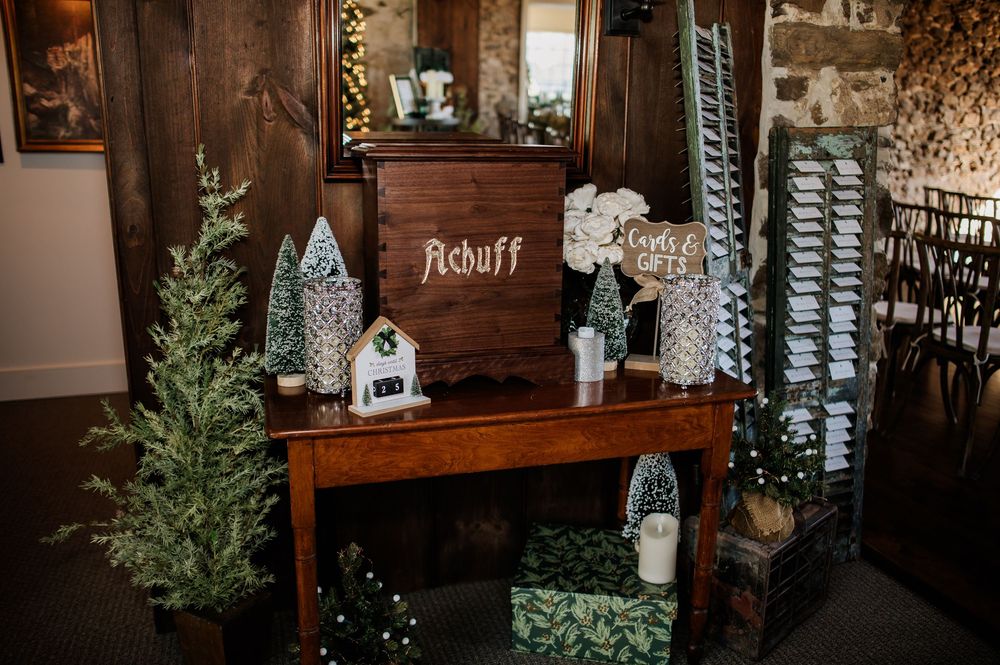 Rustic wooden shelving display with winter decorations and twinkling lights.