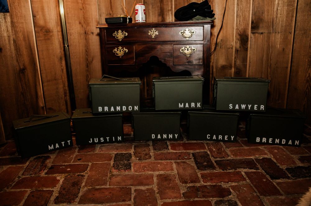 Row of name cards displayed on wooden shelves in a rustic venue setting.