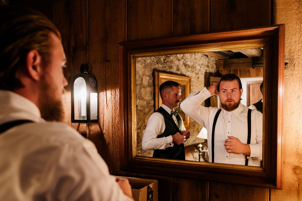 Formal event preparations in a warmly lit wood-paneled room with mirrors.