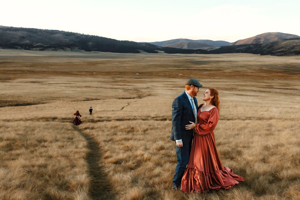 Albuquerque family in formal attire sharing romantic moment in vast golden meadow in Valles Caldera.