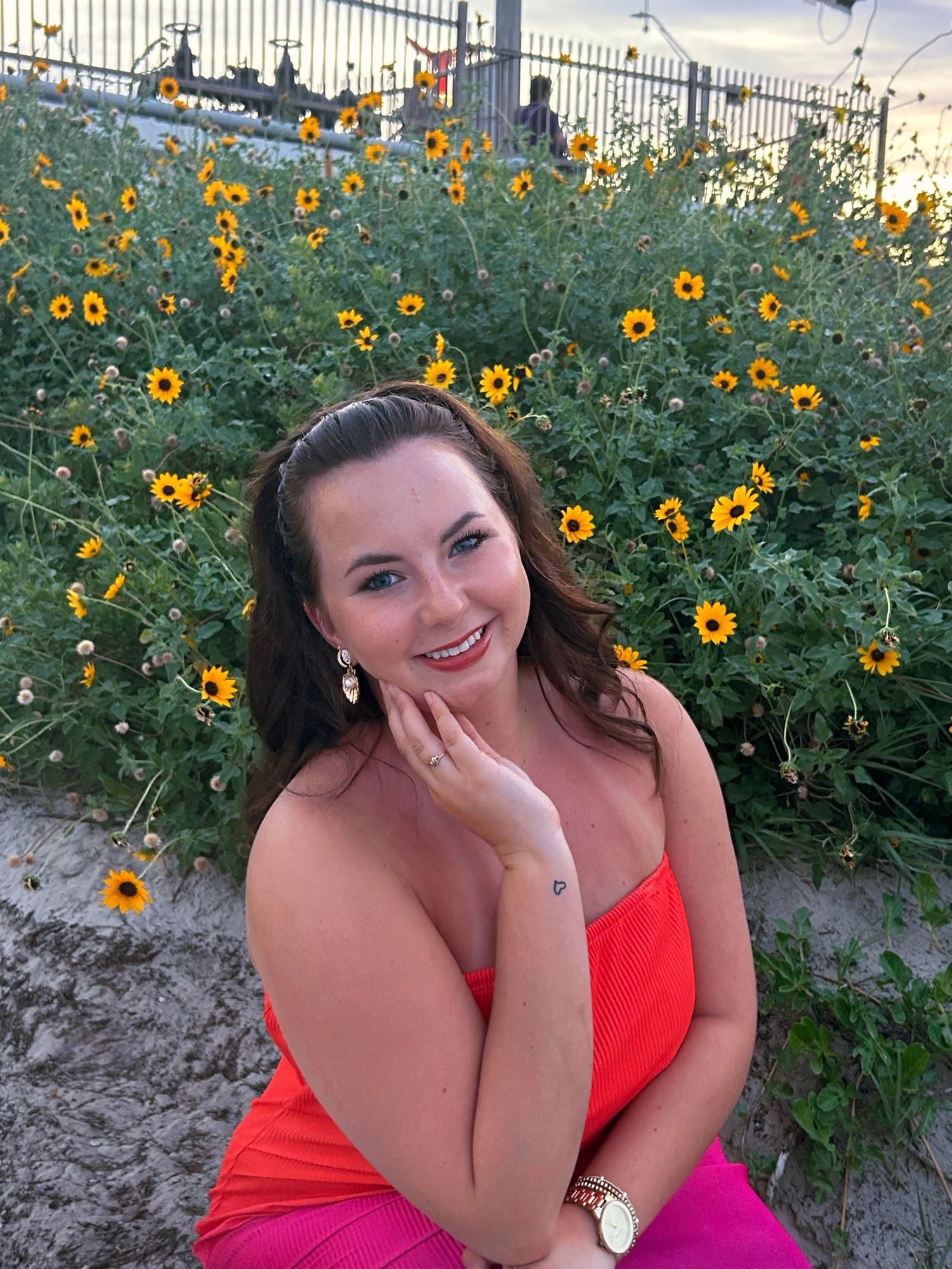 Portrait session in front of blooming sunflower garden with bright orange flowers.