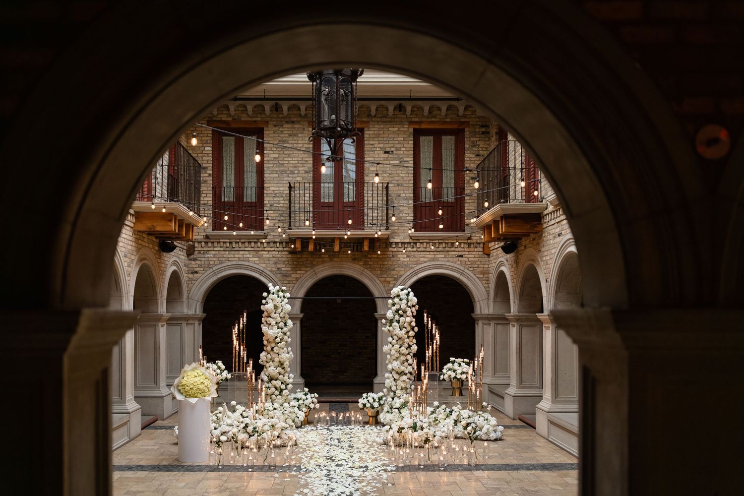 Ornate cathedral interior with grand arches, chandeliers and decorative architectural details illuminated in warm lighting.